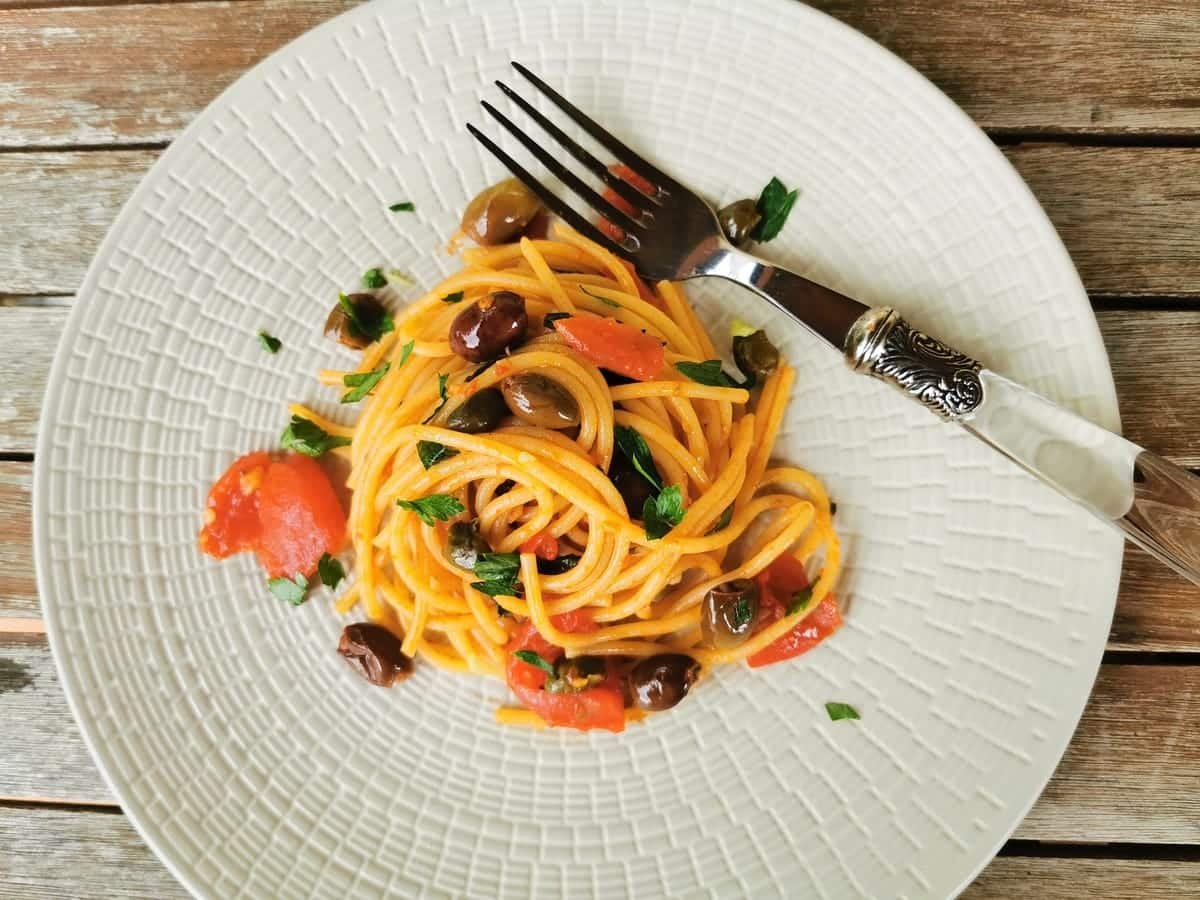 Spaghetti alla puttanesca on a plate with a fork.