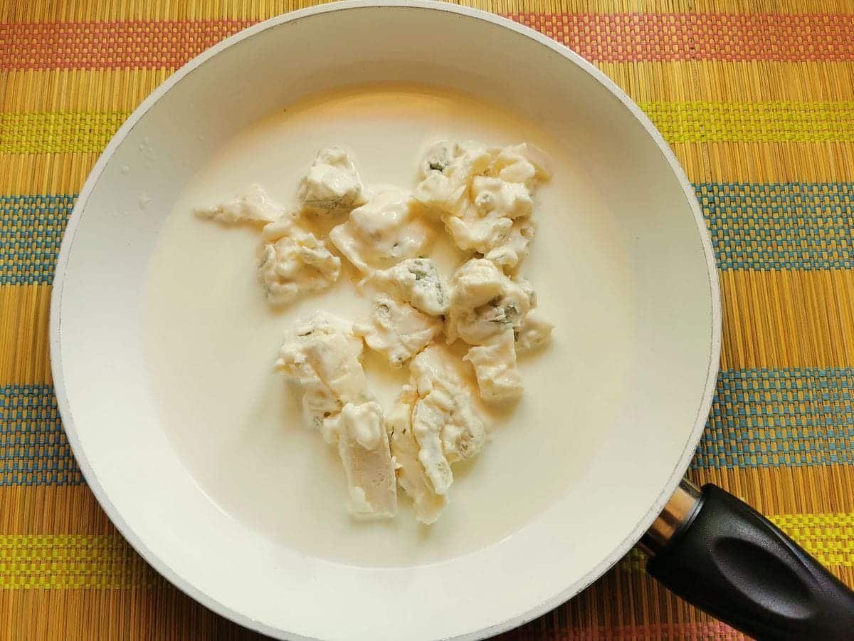 Pieces of gorgonzola with cow's milk in white pan.