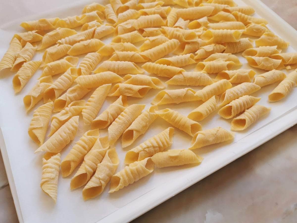 Homemade Garganelli on white tray.