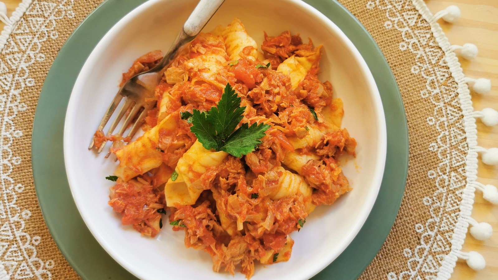 Homemade Garganelli with tunbolognis in white bowl with fork.