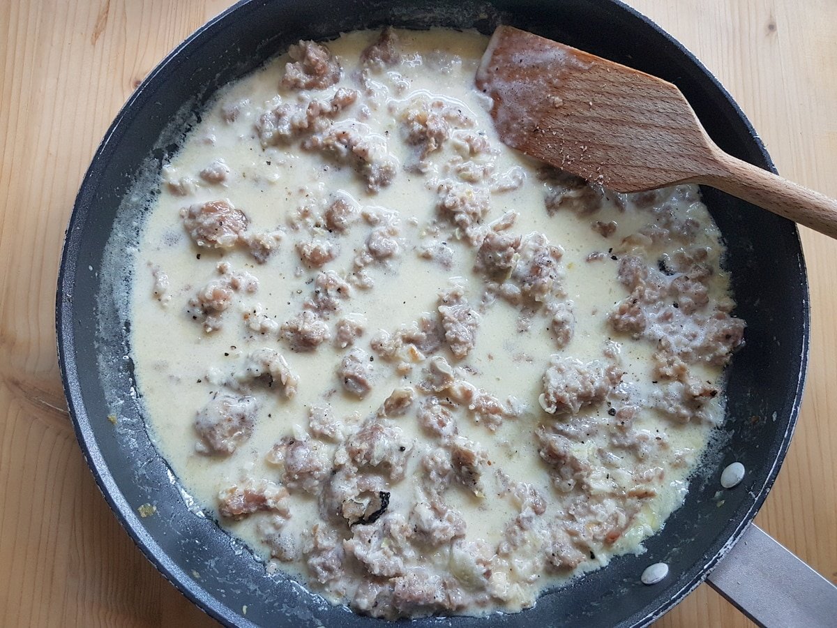 Fresh cream, truffle and pecorino added to the sausage and onion in the pan.