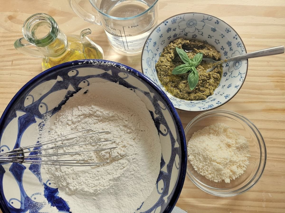Ingredients for testaroli with pesto on the woodwork.