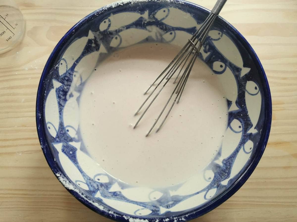 Clear testaroli dough in large bowl with whick.