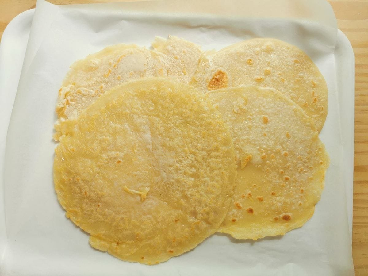 Clear testaroli -pancakes on kitchen paper covered tray.