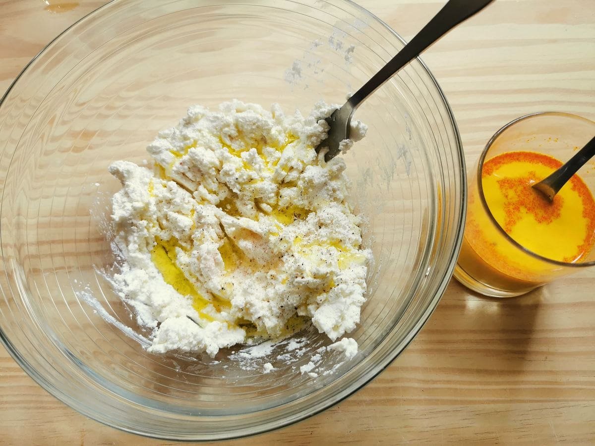 Creamy ricotta with olive oil in glass bowl and saffron powder in a glass of milk.